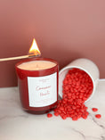 Load image into Gallery viewer, Candle labeled 'Cinnamon Hearts' with a match and red candies on a surface.
